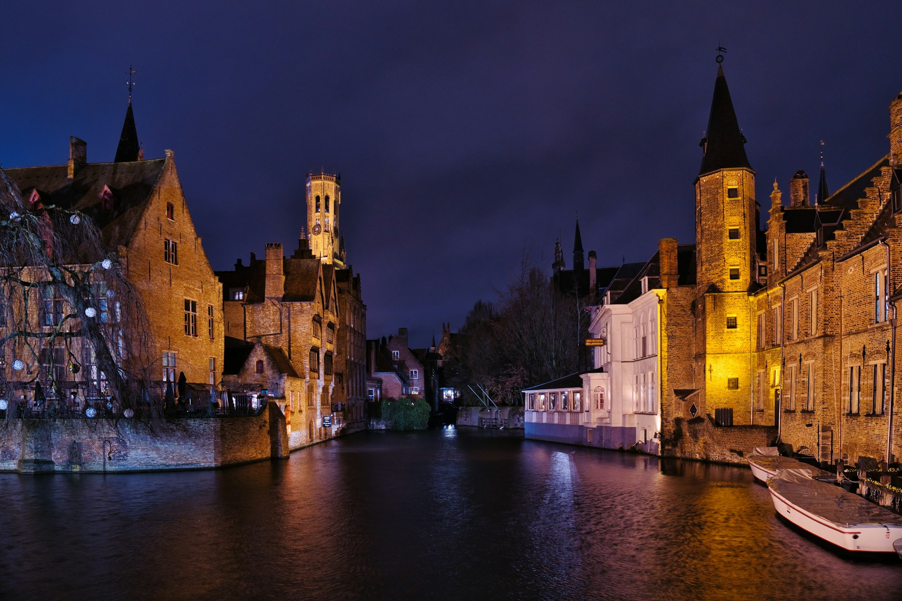 Des bâtiments historiques de Bruges illuminés au bord du canal la nuit