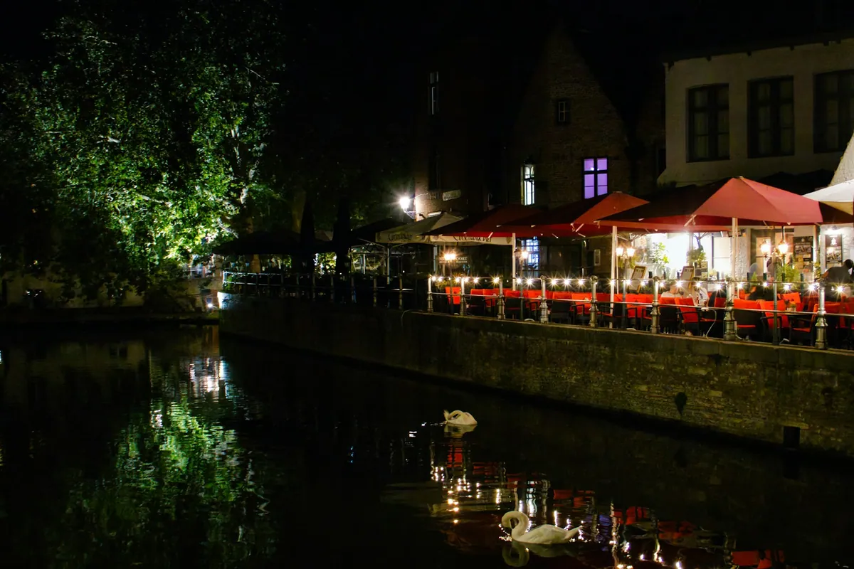People dining beside a canal in Bruges