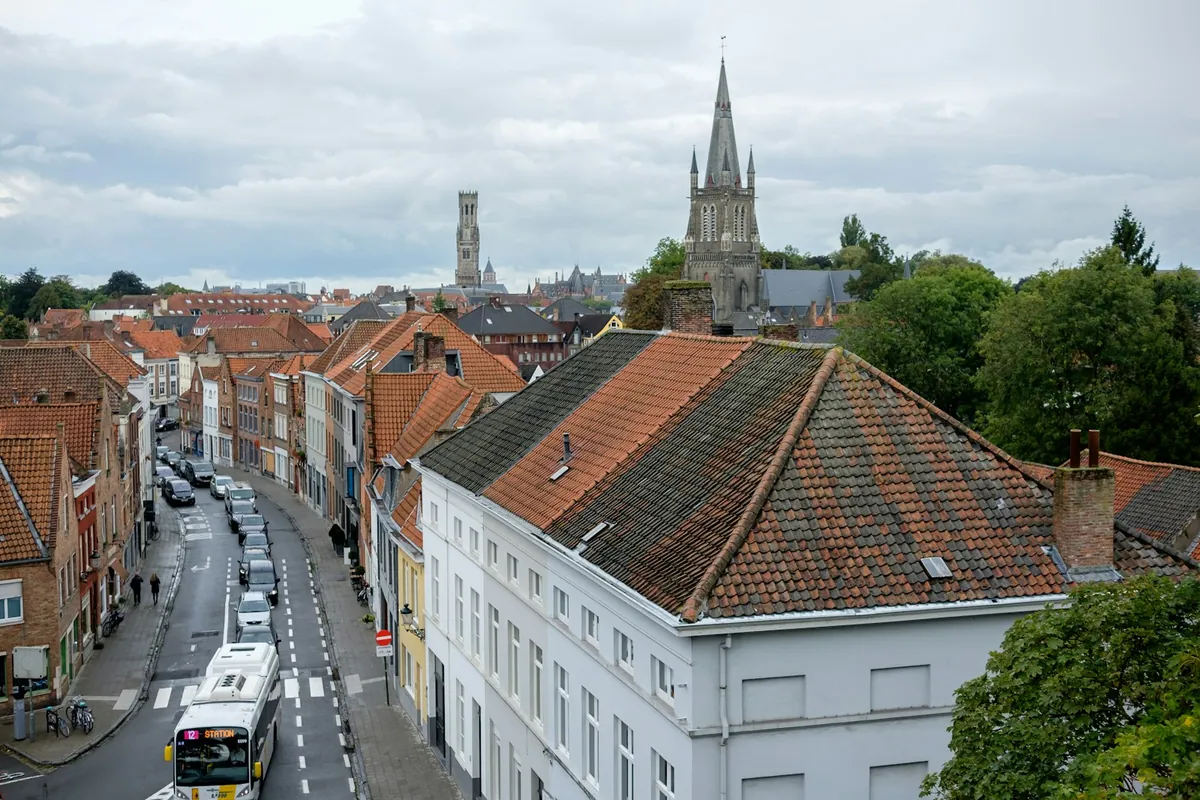 A bus travelling through a street in Bruges
